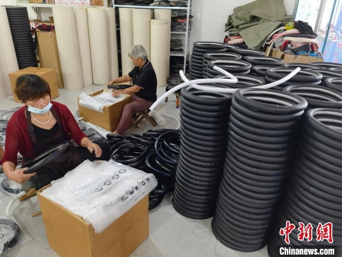 圖為村民在汽車飾品企業(yè)生產(chǎn)車間中工作?！巫雍?攝