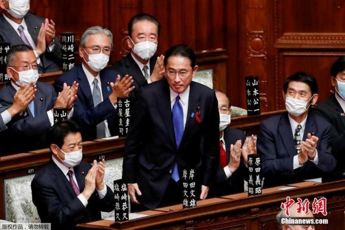 當?shù)貢r間10月4日，日本自民黨總裁岸田文雄經(jīng)過眾院全體會議的首相指名選舉成為第100任首相。圖為岸田文雄（中）起身致謝。