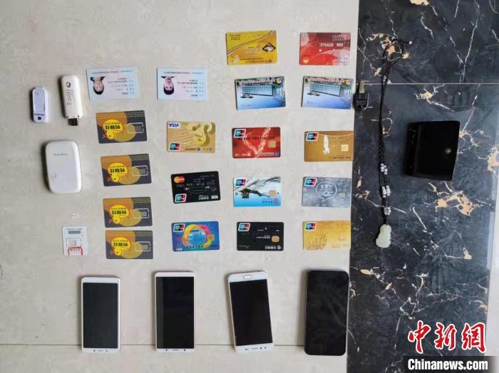 資料圖為果洛藏族自治州公安民警查扣的作案手機(jī)和涉案銀行卡?！‖斍呖h公安局供圖
