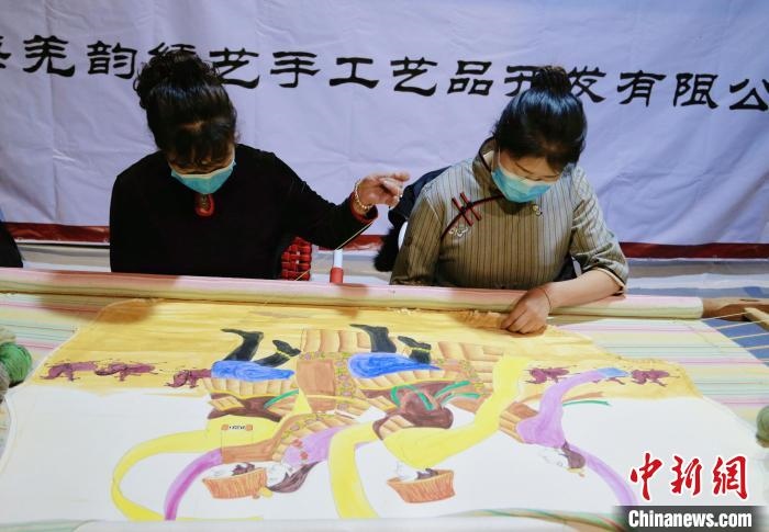 圖為皮繡藝人在市集上“秀”指尖技藝?！●R銘言 攝