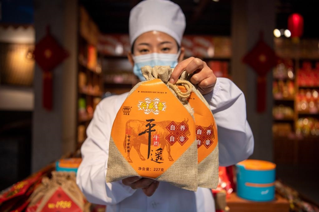 1月27日，在平遙古城南大街的一家平遙牛肉店內(nèi)，工作人員展示一款牛肉產(chǎn)品。新華社記者 楊晨光 攝