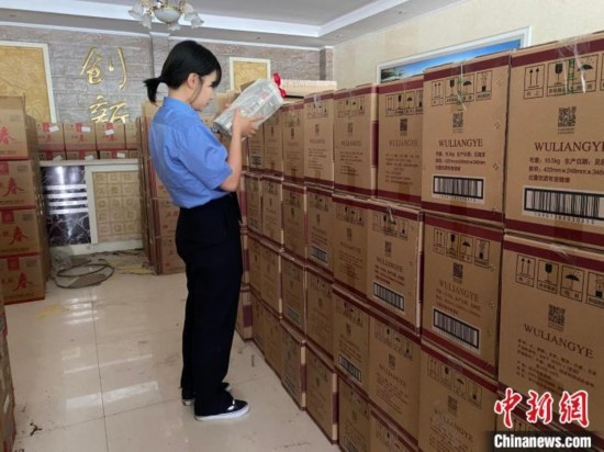 資料圖為檢察人員核對(duì)查獲的假冒品牌白酒。青海省人民檢察院供圖