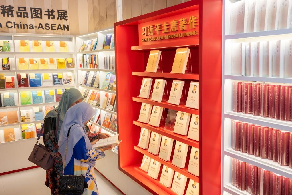 5月30日，兩名讀者在馬來西亞吉隆坡國際書展中國主賓國活動現(xiàn)場閱讀習(xí)近平主席著作。新華社記者朱煒攝