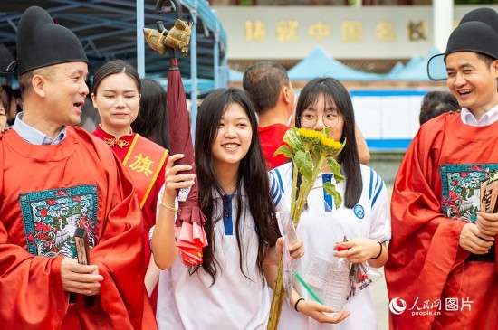 6月7日上午，在南寧市天桃實(shí)驗(yàn)學(xué)校翠竹校區(qū)，老師們?cè)跒榭忌鷤兗佑凸膭?！人民網(wǎng)記者 嚴(yán)立政攝