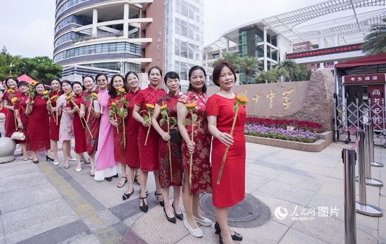 6月7日一早，廈門(mén)雙十中學(xué)考生家長(zhǎng)們身穿旗袍，手拿向日葵在考場(chǎng)外為孩子加油打氣，寓意“旗開(kāi)得勝，一舉奪魁”。人民網(wǎng)記者 陳博攝