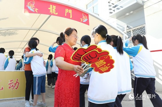 6月7日一早，雄安新區(qū)安新中學(xué)老師在給同學(xué)們加油鼓勁兒。人民網(wǎng) 李兆民攝