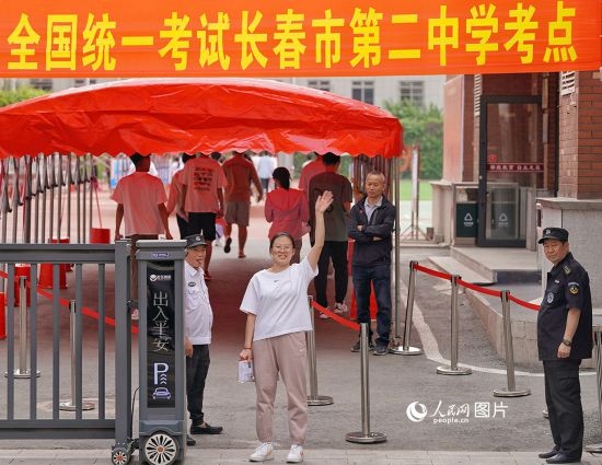 6月7日，在長(zhǎng)春市第二中學(xué)考點(diǎn)，一名考生信心滿滿進(jìn)入考場(chǎng)，并與家長(zhǎng)揮手致意。人民網(wǎng)記者 李洋攝