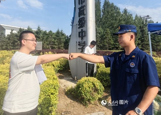6月7日，遼寧營(yíng)口老邊區(qū)消防救援大隊(duì)的消防員為高考學(xué)子加油助威。人民網(wǎng)記者 尹柏寒?dāng)z