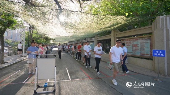 6月7日，烏魯木齊市第七十中學(xué)門(mén)口，考生們有序進(jìn)入考場(chǎng)。人民網(wǎng) 李欣洋攝