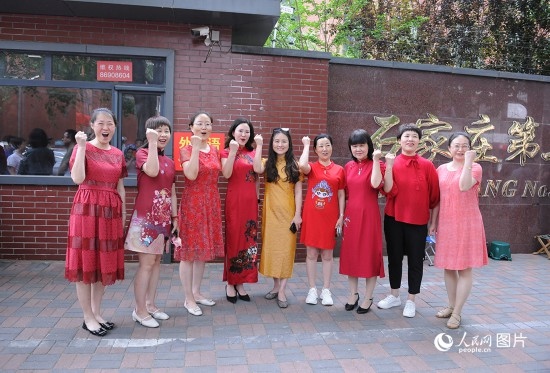 6月7日，在石家莊第二十七中學(xué)考點(diǎn)，家長(zhǎng)身著旗袍，為高考的孩子們加油助威！紅紅火火、旗開(kāi)得勝！人民網(wǎng)記者 周博攝
