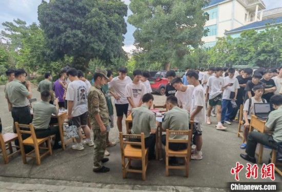 專武干部在發(fā)放兵役登記證。韋碩 攝