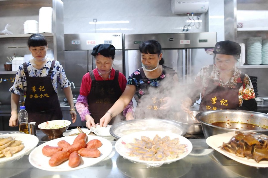 福建三明市沙縣區(qū)一家小吃店工作人員在為客人準(zhǔn)備特色小吃。 新華社記者 林善傳 攝