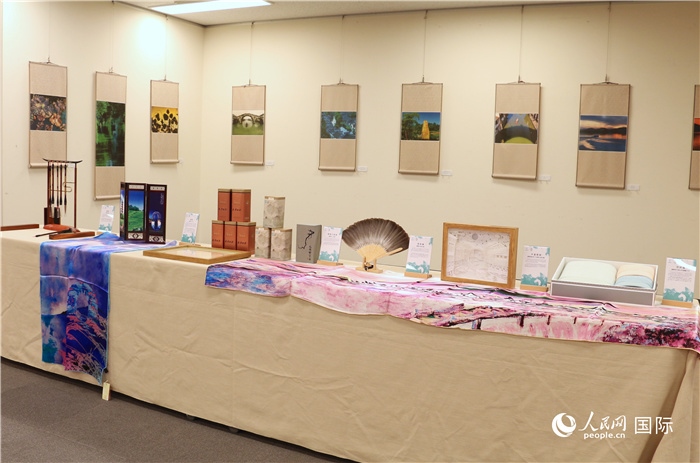 現(xiàn)場(chǎng)展出的馮學(xué)敏攝影作品與湖州市特色工藝品。（人民網(wǎng) 許可攝）