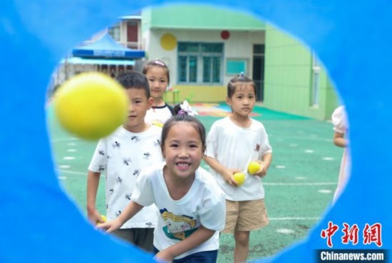 在肥西縣山南鎮(zhèn)中心幼兒園，孩子們在玩布洞投球游戲。陳家樂 攝