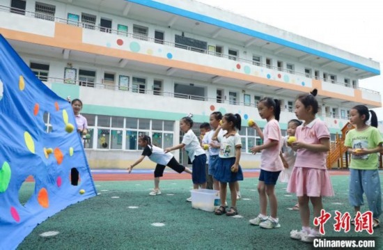 在肥西縣山南鎮(zhèn)中心幼兒園，孩子們在玩布洞投球游戲。陳家樂 攝