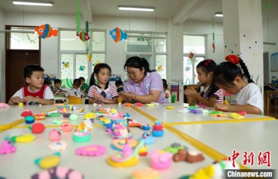 在肥西縣山南鎮(zhèn)中心幼兒園，孩子們在老師的指導(dǎo)下做彩色泥塑。陳家樂 攝