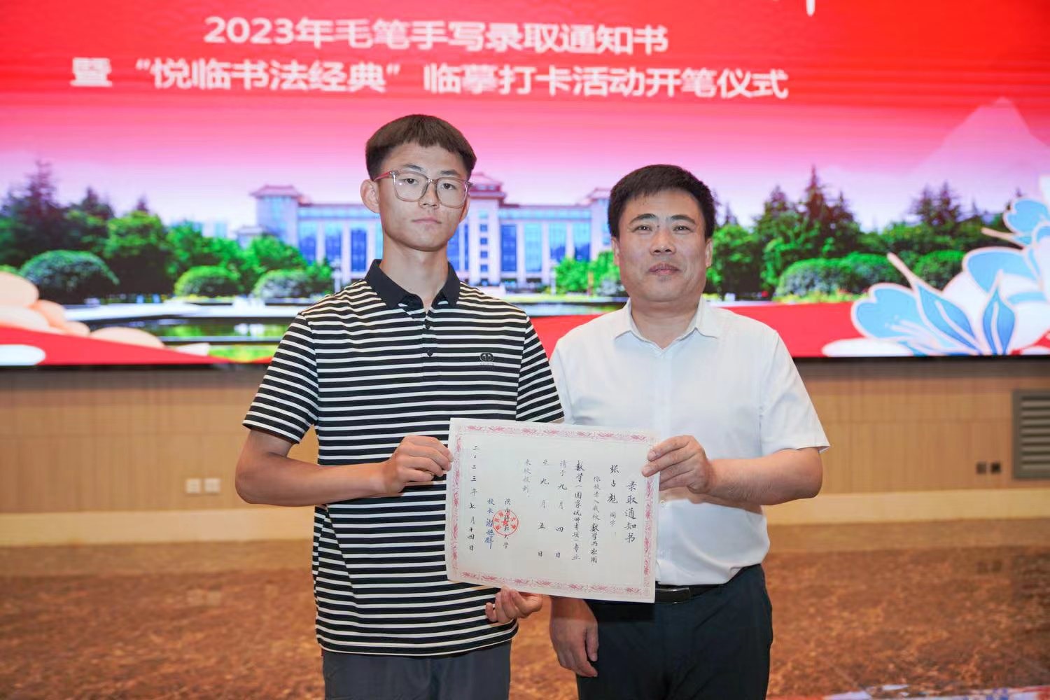 陜西師范大學(xué)黨委書記李忠軍為2023級(jí)新生代表張占彪同學(xué)發(fā)放錄取通知書。校方供圖
