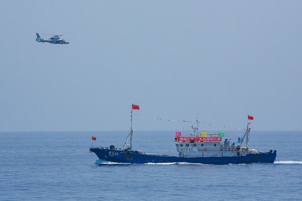 ↑中國(guó)海軍第40批護(hù)航編隊(duì)中的艦載直升機(jī)在被護(hù)船只周邊海域巡邏警戒（2022年6月4日攝）。新華社發(fā)（唐文 攝）