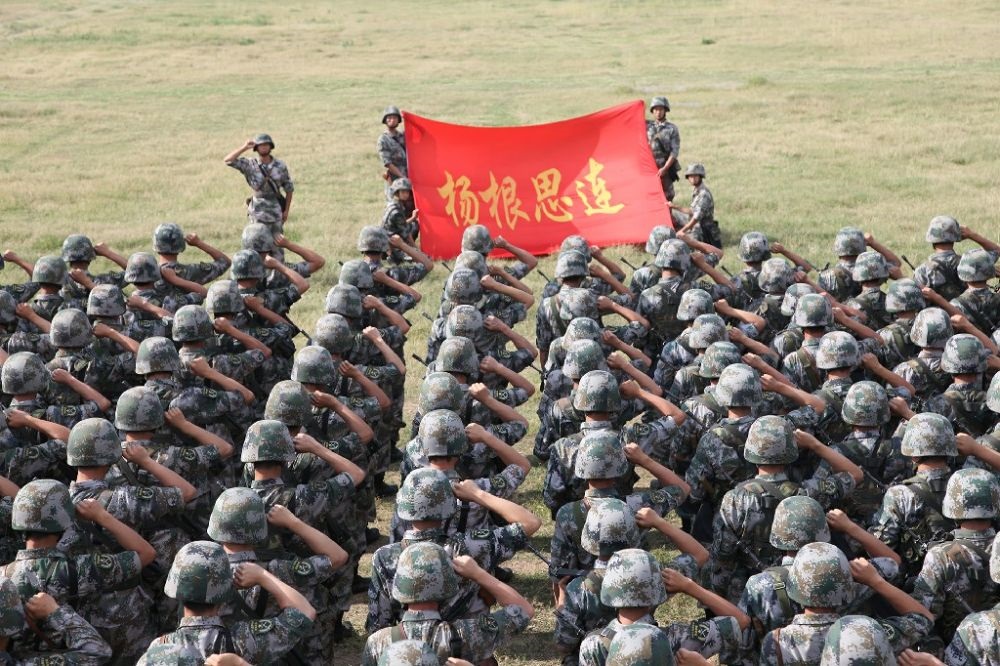 ↑“楊根思連”官兵執(zhí)行任務(wù)前向連旗宣誓（資料照片）。新華社發(fā)