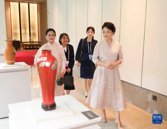 7月27日下午，國家主席習近平夫人彭麗媛在四川成都會見陪同印度尼西亞總統(tǒng)佐科來華出席第31屆世界大學生夏季運動會開幕式并訪華的總統(tǒng)夫人伊莉亞娜。這是彭麗媛和伊莉亞娜欣賞成都特色非遺工藝品。新華社記者 丁林 攝
