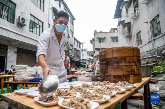 7月29日，在重慶市綦江區(qū)安穩(wěn)鎮(zhèn)，當?shù)鼐用裨凇懊缂曳蚬?jié)”上準備羊肉長桌宴。新華社記者 唐奕 攝