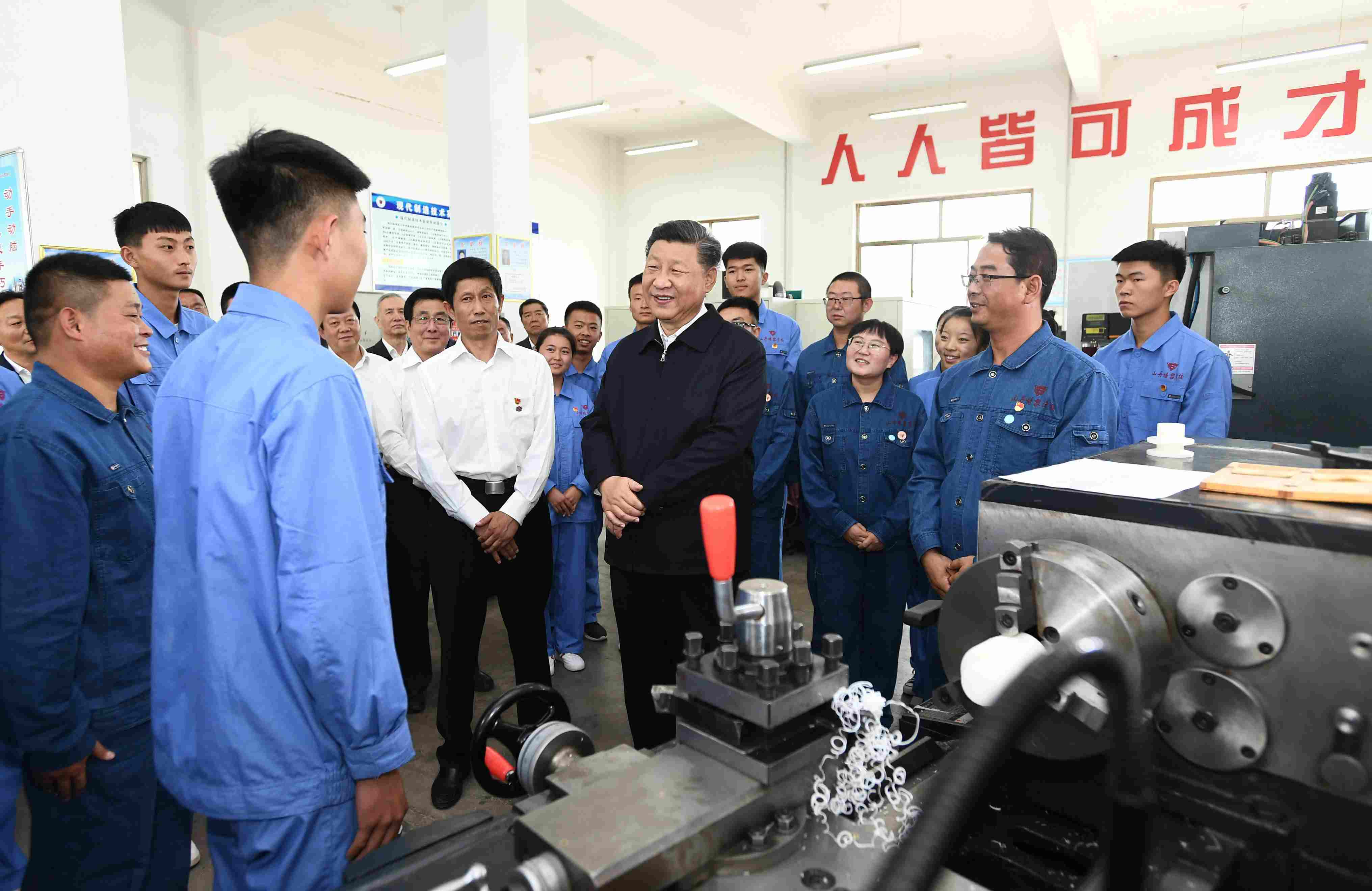 2019年8月20日，習(xí)近平在甘肅省張掖市山丹培黎學(xué)校現(xiàn)代制造技術(shù)實訓(xùn)室，觀看職業(yè)技能實訓(xùn)，同師生親切交流。