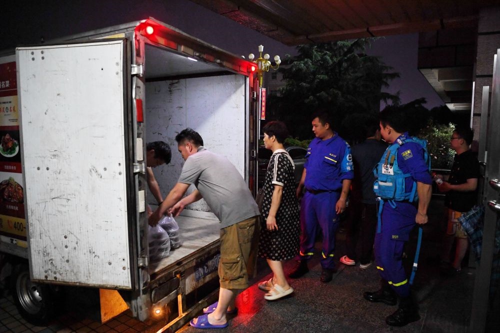 河北省涿州市職教中心安置點的工作人員在運送飯菜，準備發(fā)放給安置群眾（8月1日攝）。新華社記者 牟宇 攝