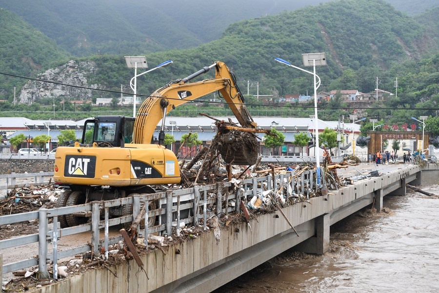 8月1日，在北京市門頭溝區(qū)水峪嘴村村口，一臺挖掘機在清理阻斷橋梁交通的雜物。目前該條道路已經(jīng)疏通完成。新華社記者 鞠煥宗 攝