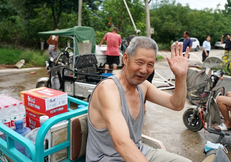 8月5日，從安置點回來的北京市房山區(qū)青龍湖鎮(zhèn)口頭村村民高大爺領到生活物資準備回家。新華社記者 張晨霖 攝