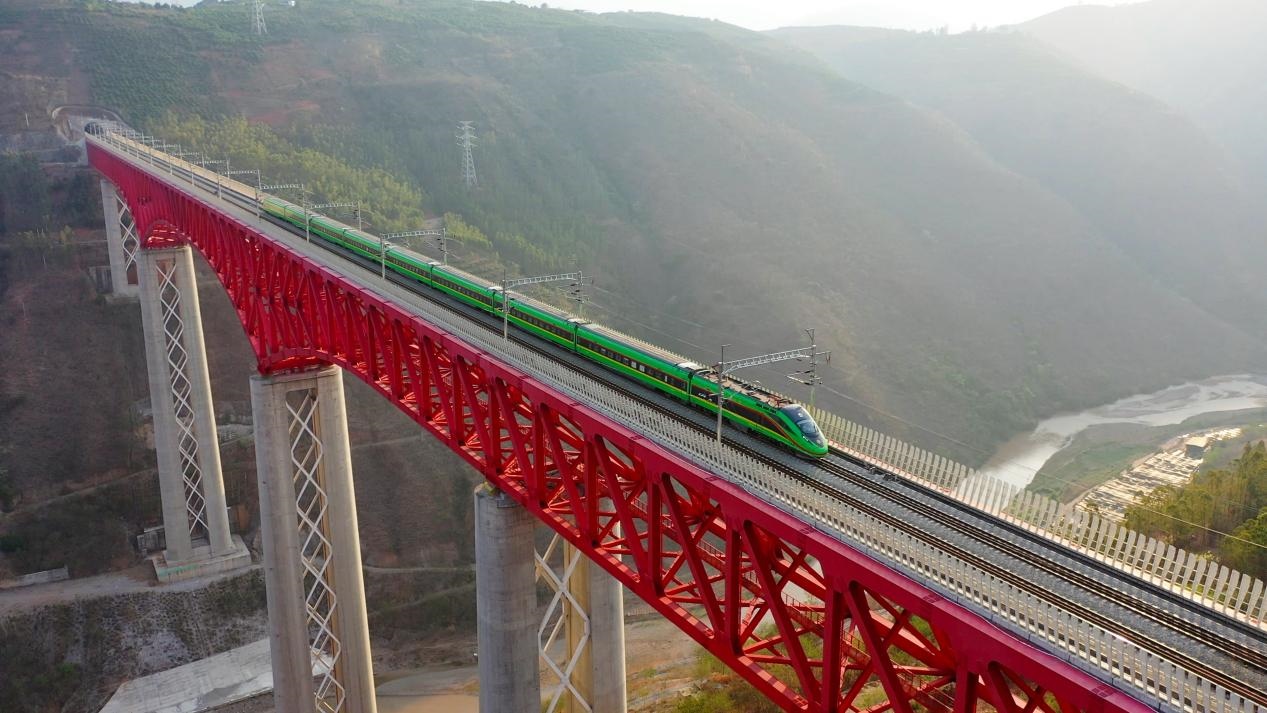 中老鐵路國際旅客列車在云南省境內(nèi)的元江特大橋上飛馳。姚巍攝
