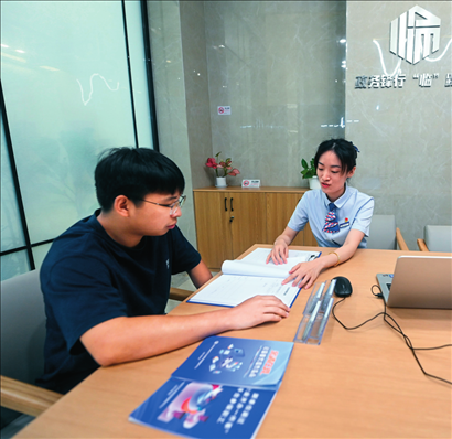 在杭州市臨安區(qū)政務(wù)服務(wù)中心的“為企服務(wù)中心”，黨員志愿者（右）解答企業(yè)主的疑問(wèn)（2023年7月7日攝）。徐昱攝/本刊