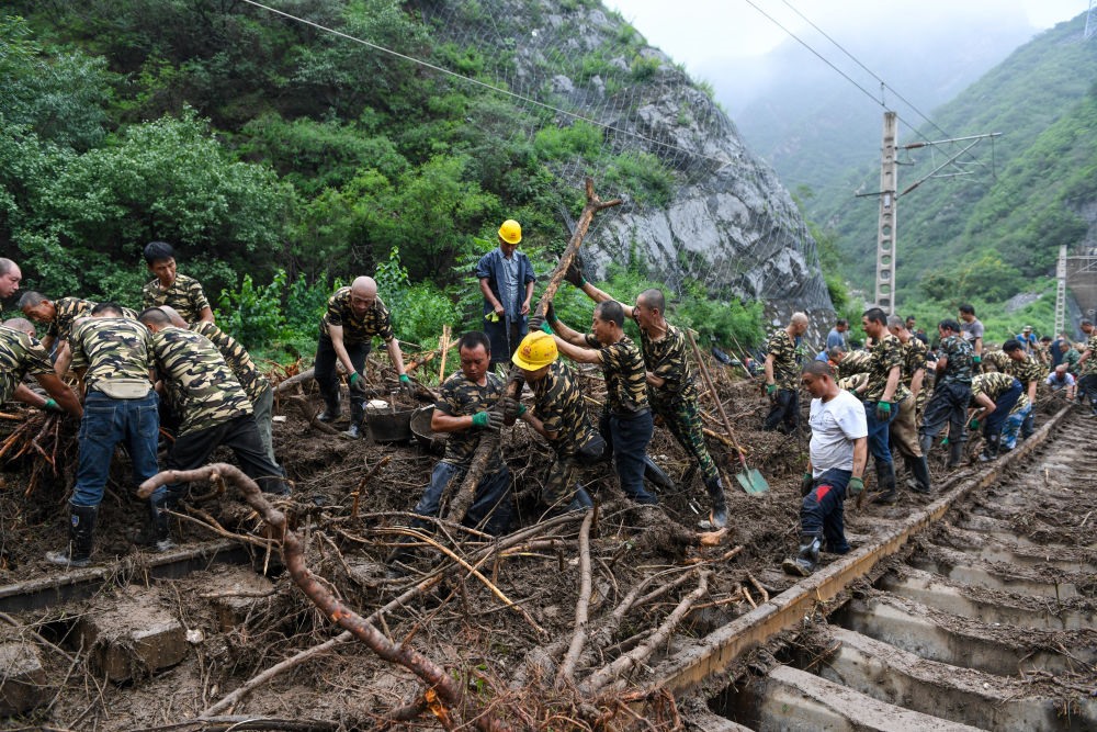 8月1日，在北京市門頭溝區(qū)水峪嘴村附近一段被阻斷的鐵路線上，中鐵六局工作人員在清理軌道上的雜物，全力恢復(fù)交通。新華社記者 鞠煥宗 攝