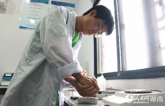 吳健筆在獼猴桃科技小院實驗室測量水果糖分。 人民網(wǎng)記者 劉賓攝