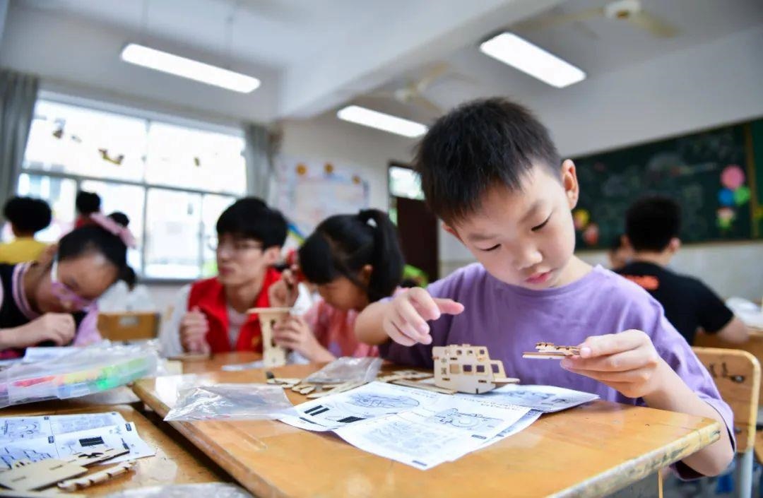 △今年7月，在浙江余姚市舜北小學(xué)暑托班內(nèi)，孩子們制作太陽能科學(xué)實(shí)驗(yàn)裝置。