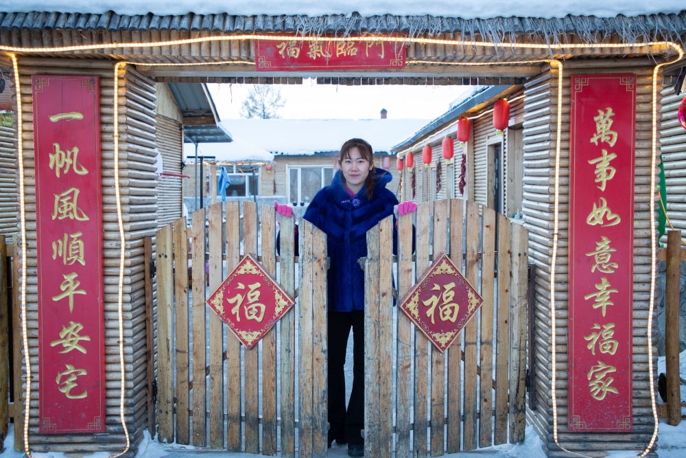 北極村民宿經(jīng)營(yíng)者史瑞娟在門前迎候入住的游客（2023年1月7日攝）。