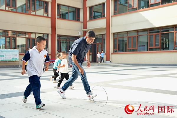 來自巴基斯坦的沙杰在滾鐵環(huán)。人民網(wǎng) 盧鵬宇攝