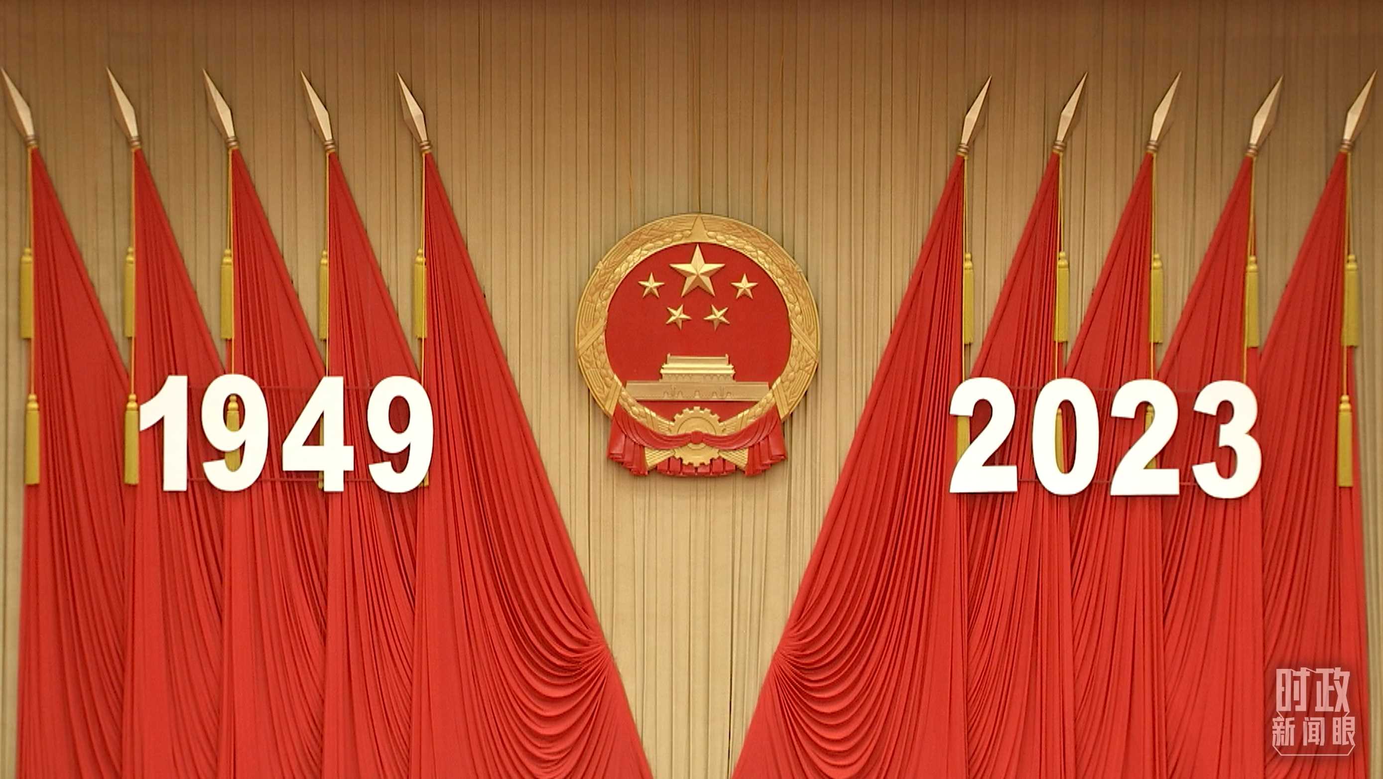 △人民大會(huì)堂宴會(huì)廳內(nèi)，主席臺(tái)上方高懸著莊嚴(yán)的國(guó)徽，“1949－2023”大字年號(hào)在鮮艷的紅旗映襯下格外醒目。