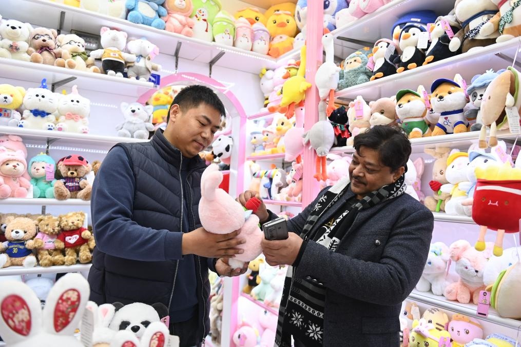 2023年2月2日，來自印度的客商（右）在義烏國際商貿(mào)城的一家玩具店鋪內(nèi)選購商品。新華社記者 黃宗治 攝
