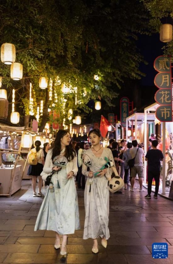 在成都寬窄巷子，兩位來(lái)自安徽的游客在新“十二月市”街區(qū)游覽（9月29日攝）。