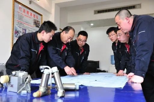 △李志強（左二）與班組成員在研究工作。