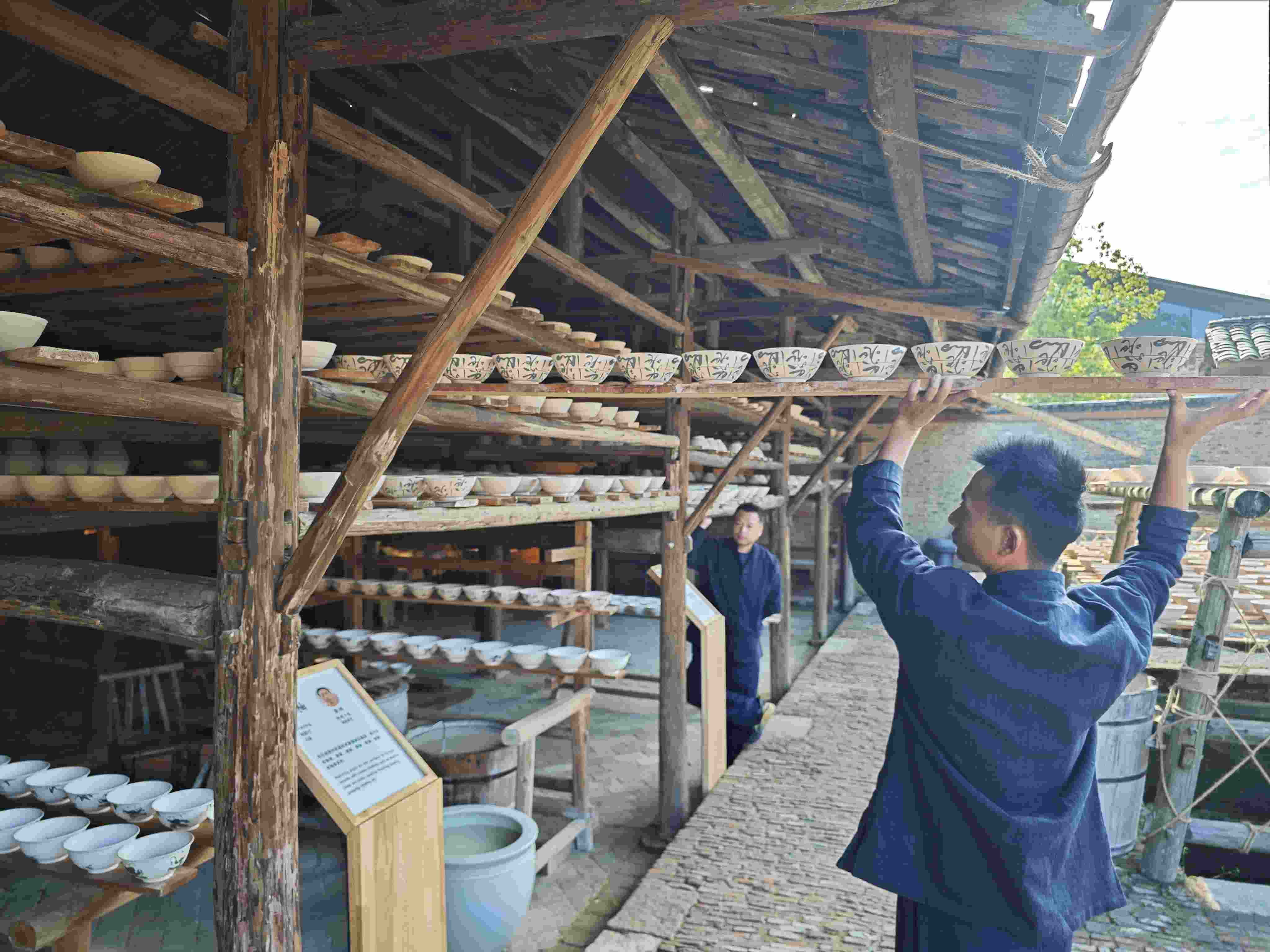 △陶陽(yáng)里歷史文化街區(qū)里，工匠將陶瓷工藝品放到架上晾干。（總臺(tái)央視記者彭漢明拍攝）