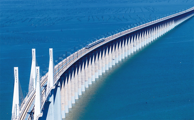 2023年9月28日，中國首條時速350公里跨海高鐵——福廈高鐵正式開通運(yùn)營。圖為一列運(yùn)行試驗車組駛過福廈高鐵湄洲灣跨海大橋（9月19日攝，無人機(jī)照片）。 新華社記者 魏培全/攝