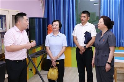圖③：“小公民法律課堂”開講前，全國人大代表殷其龍（右二）、重慶市人大代表李自玲（左二）聽取楊家坪中學(xué)負(fù)責(zé)人關(guān)于未成年人思想教育工作情況的介紹。
