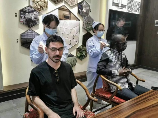 2023“一帶一路”媒體合作論壇聯(lián)合采訪團(tuán)團(tuán)員在九牛草展示館體驗艾灸。（本報記者 黃超攝）