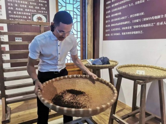 2023“一帶一路”媒體合作論壇聯(lián)合采訪團(tuán)團(tuán)員在非遺文化展示館體驗中藥炮制技藝。（本報記者 黃超攝）