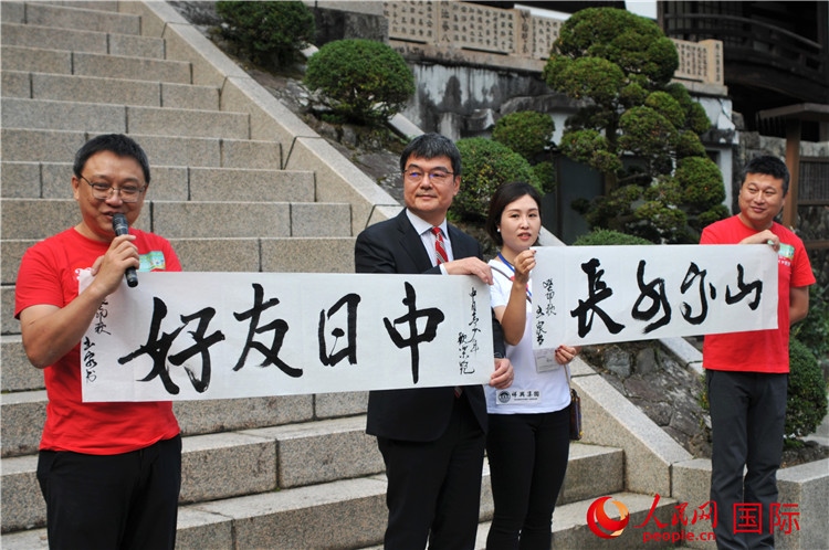 東京中國文化中心主任羅玉泉展示其為本次活動書寫的題詞“中日友好，山高水長”。人民網(wǎng) 蔣曉辰攝