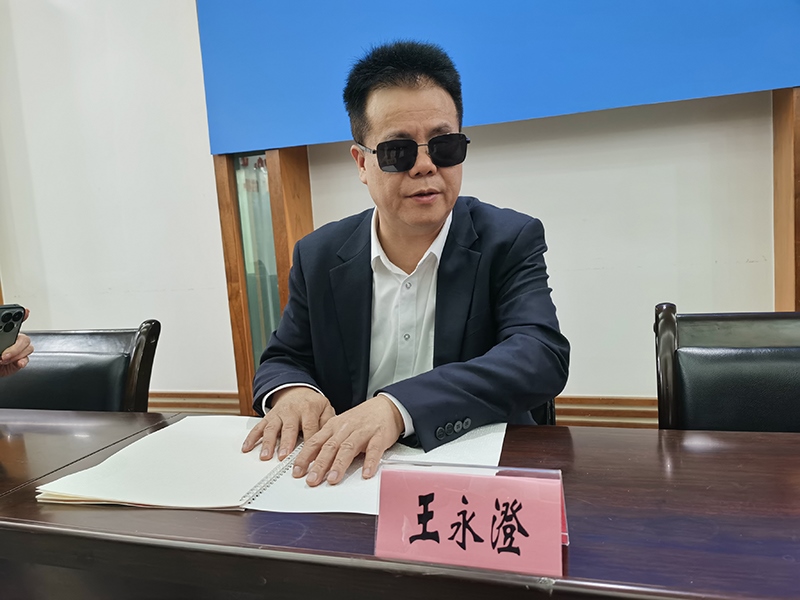 全國人大代表王永澄正在閱讀盲文版代表建議答復(fù)。本報(bào)記者 張 璁?dāng)z