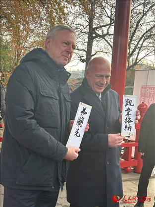 柏林市長(zhǎng)韋格納（右）、動(dòng)物園監(jiān)事會(huì)主席布魯克曼（左）手持中國(guó)文化中心工作人員現(xiàn)場(chǎng)手書的中文名字。人民網(wǎng)記者 徐馨攝