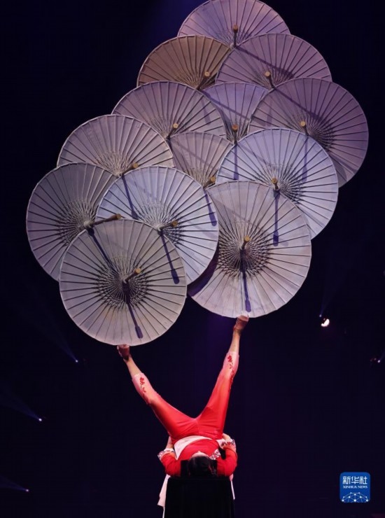 12月8日，演員在法國(guó)巴黎舉行的中國(guó)雜技“奇妙之夜”演出上表演《蹬傘》。新華社記者 高靜 攝