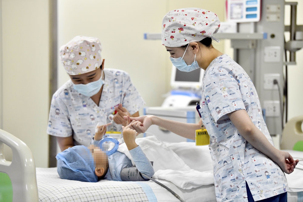 在山東省棗莊市婦幼保健院兒童ICU病房，醫(yī)護(hù)人員為完成靶向治療藥物諾西那生鈉的4歲脊髓性肌萎縮癥患兒加油鼓勁（2022年1月1日攝）。諾西那生鈉注射液是我國首個獲批治療脊髓性肌萎縮癥的進(jìn)口藥物，2019年進(jìn)入中國市場時，每針價格近70萬元。在2021年國家醫(yī)保目錄藥品談判中，以3.3萬元每針的價格進(jìn)入新版醫(yī)保藥品目錄。新華社記者 郭緒雷 攝